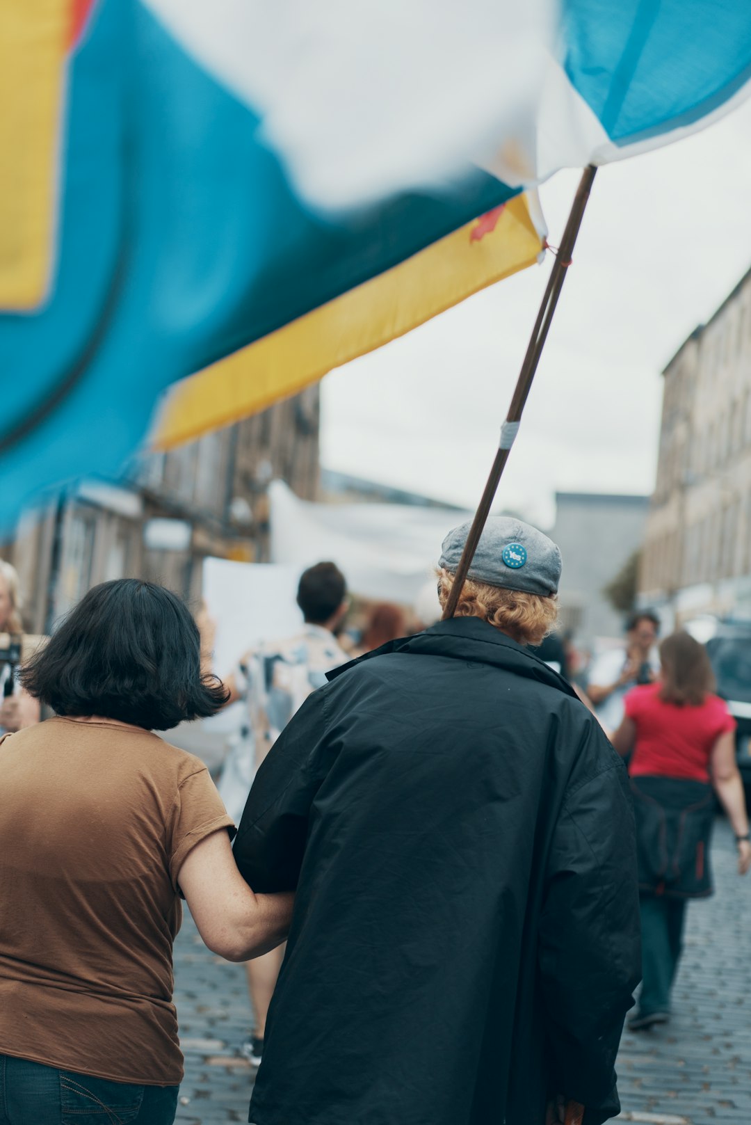 selective focus photography of woman holding arms of man