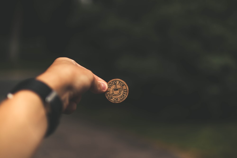 Selektive Fokusfotografie eines Mannes, der eine Münze hält