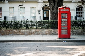 red telephone booth beside road