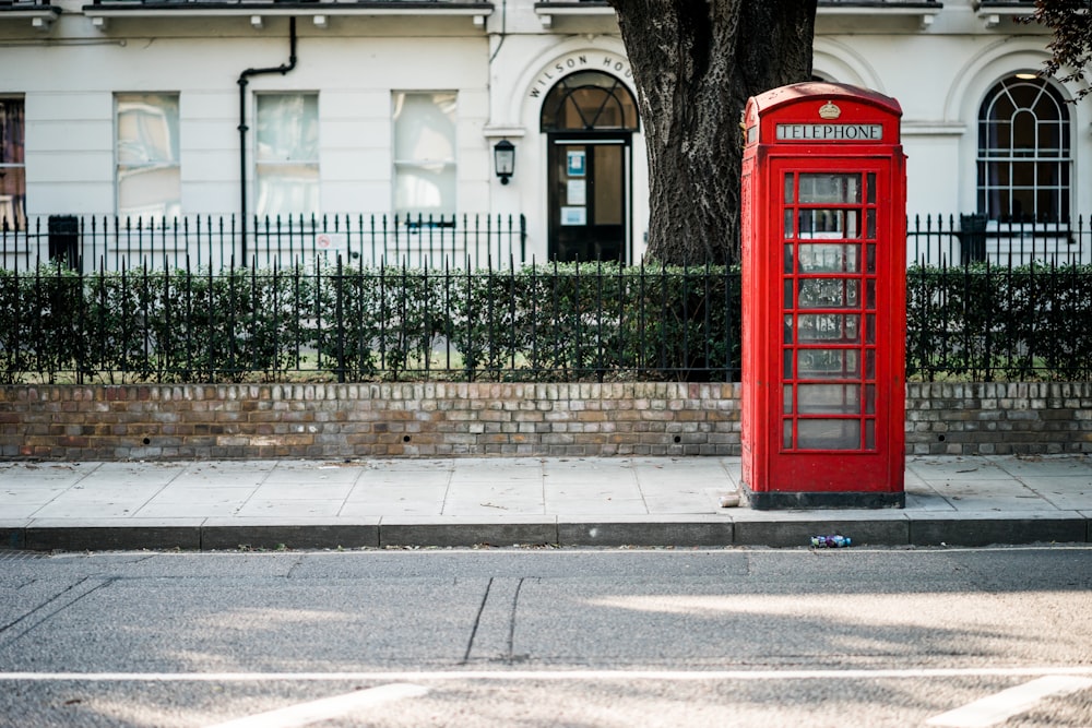 red telephone booth beside road