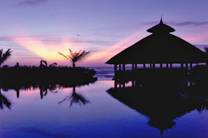 Sunset view over a cozy beachfront guesthouse in Macaneta with palm trees swaying gently