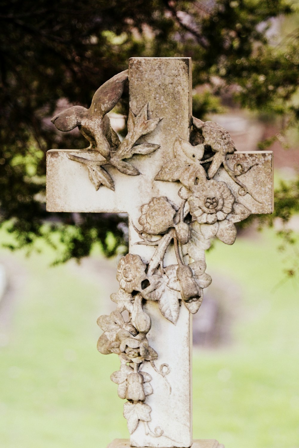베이지색과 흰색 꽃무늬 콘크리트 십자가