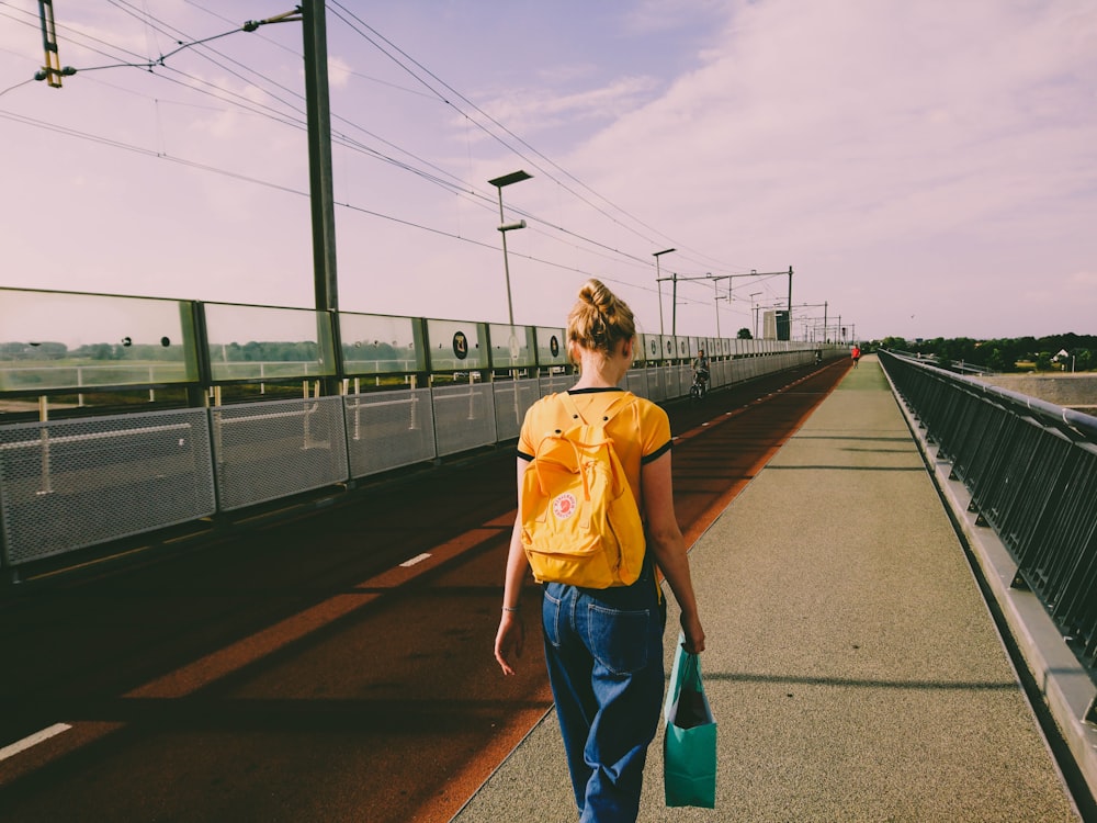 woman in yellow walking on street