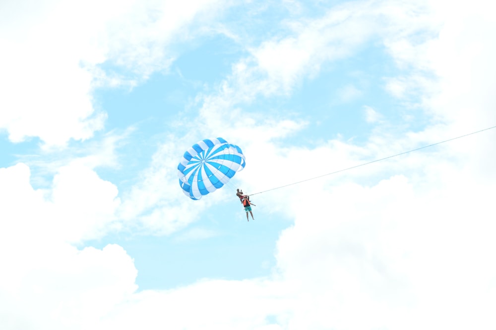 person riding on blue parachute