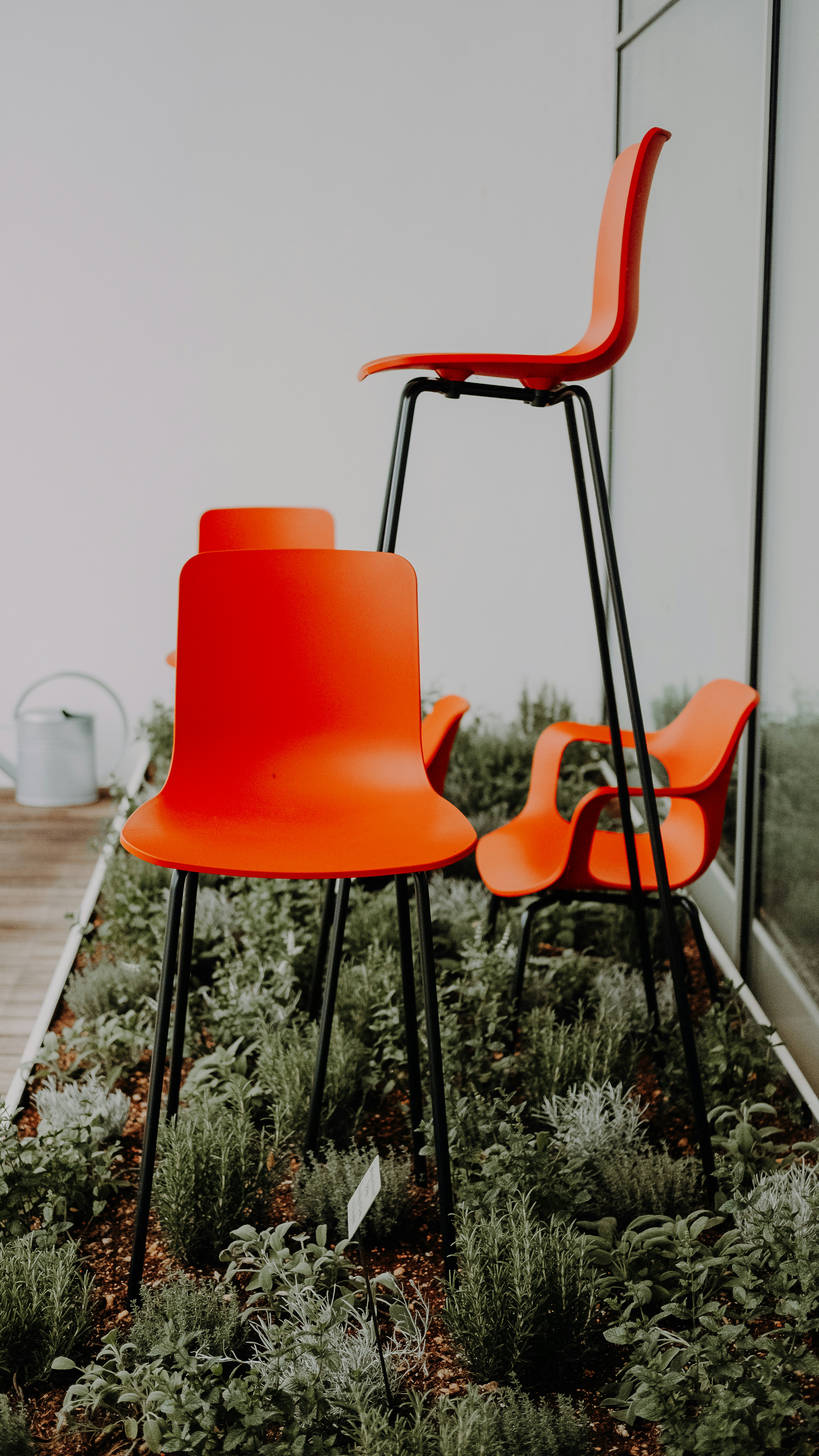 three assorted-size orange chairs on green garden