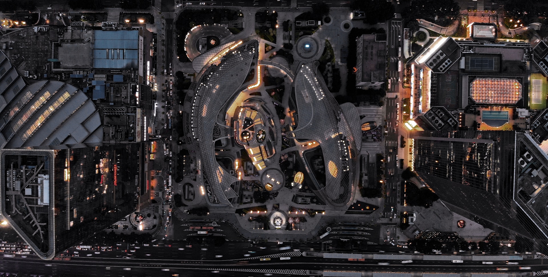 A high-resolution photo of a sleek, futuristic cityscape at night with glowing lights and dynamic architecture.