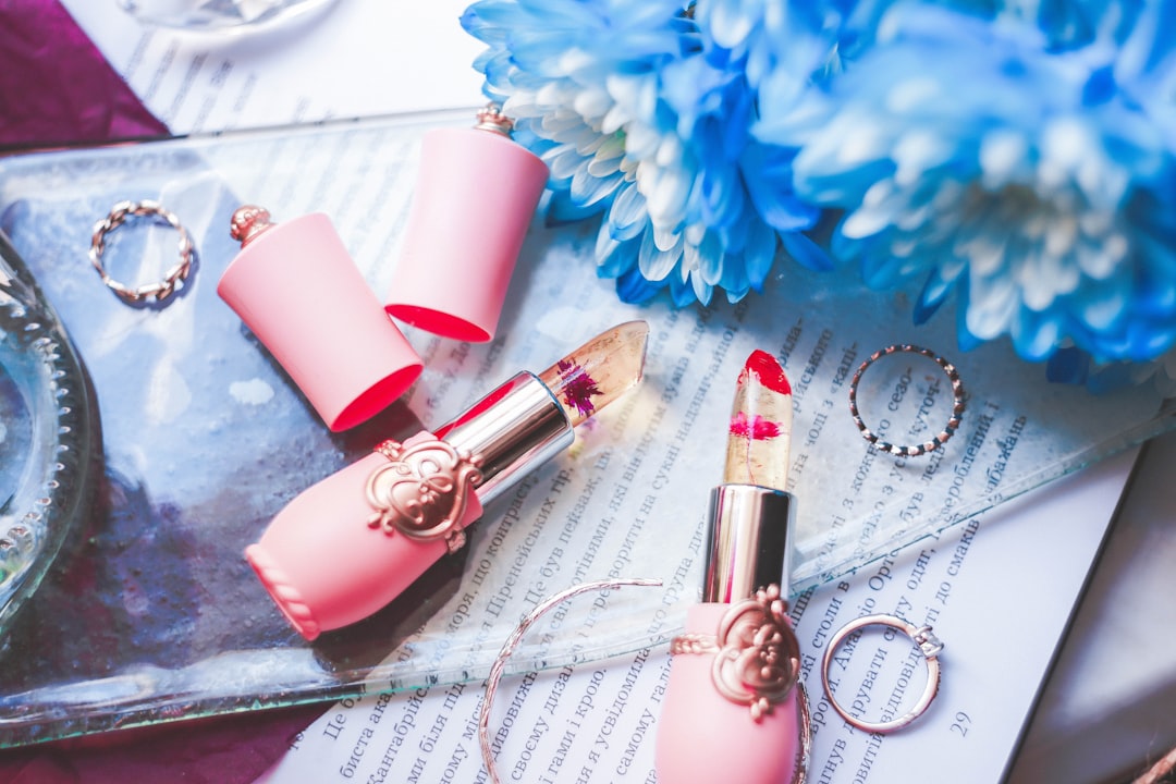 lipsticks beside blue petaled flowers