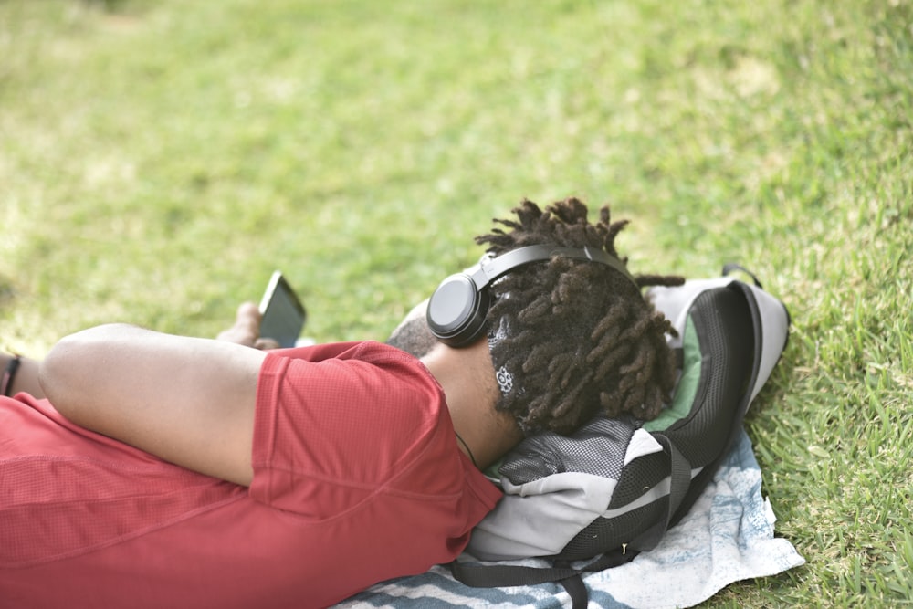 man laying on gray backpack