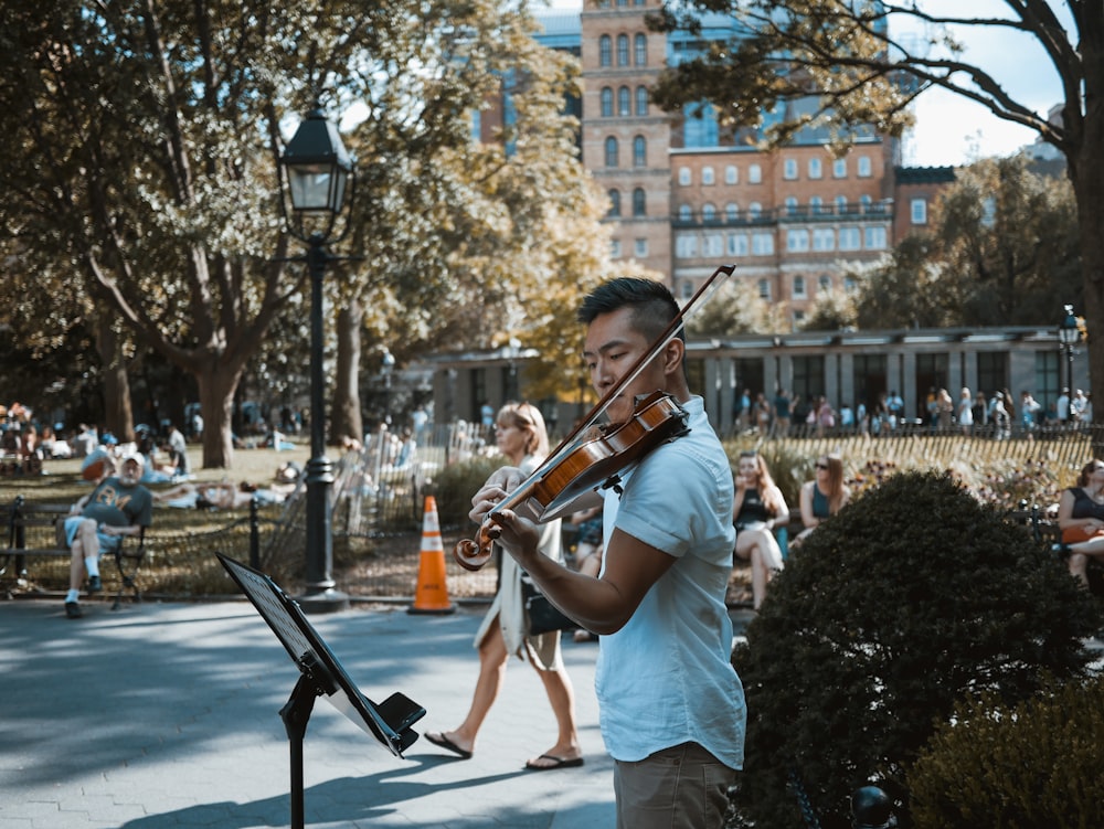 man playing violin at the park