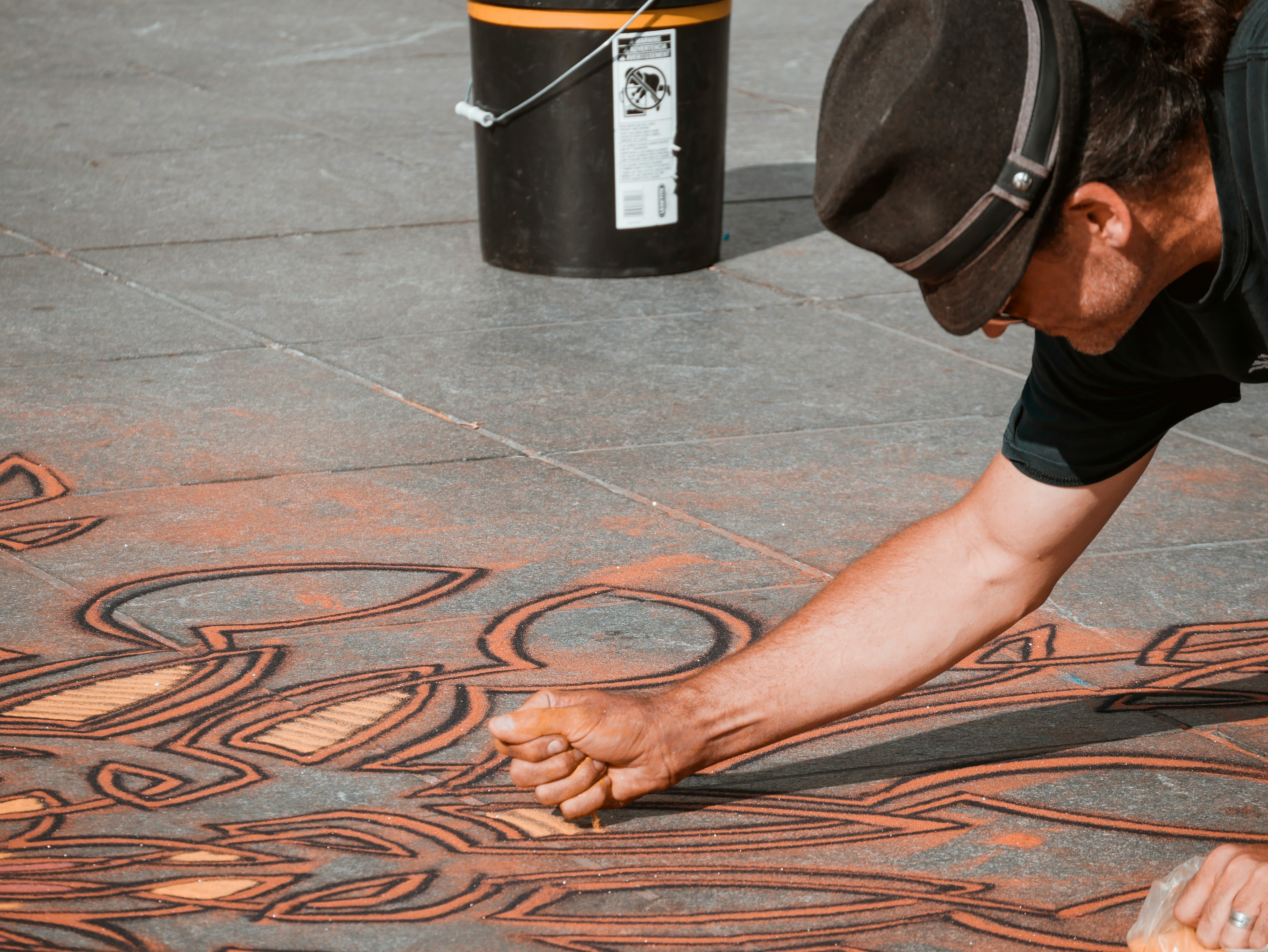 man making sand artwork on the floor