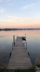 A freshly installed wooden dock extending into a calm lake at sunset.