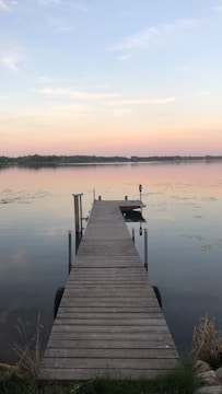 A freshly installed wooden dock extending into a calm lake at sunset.
