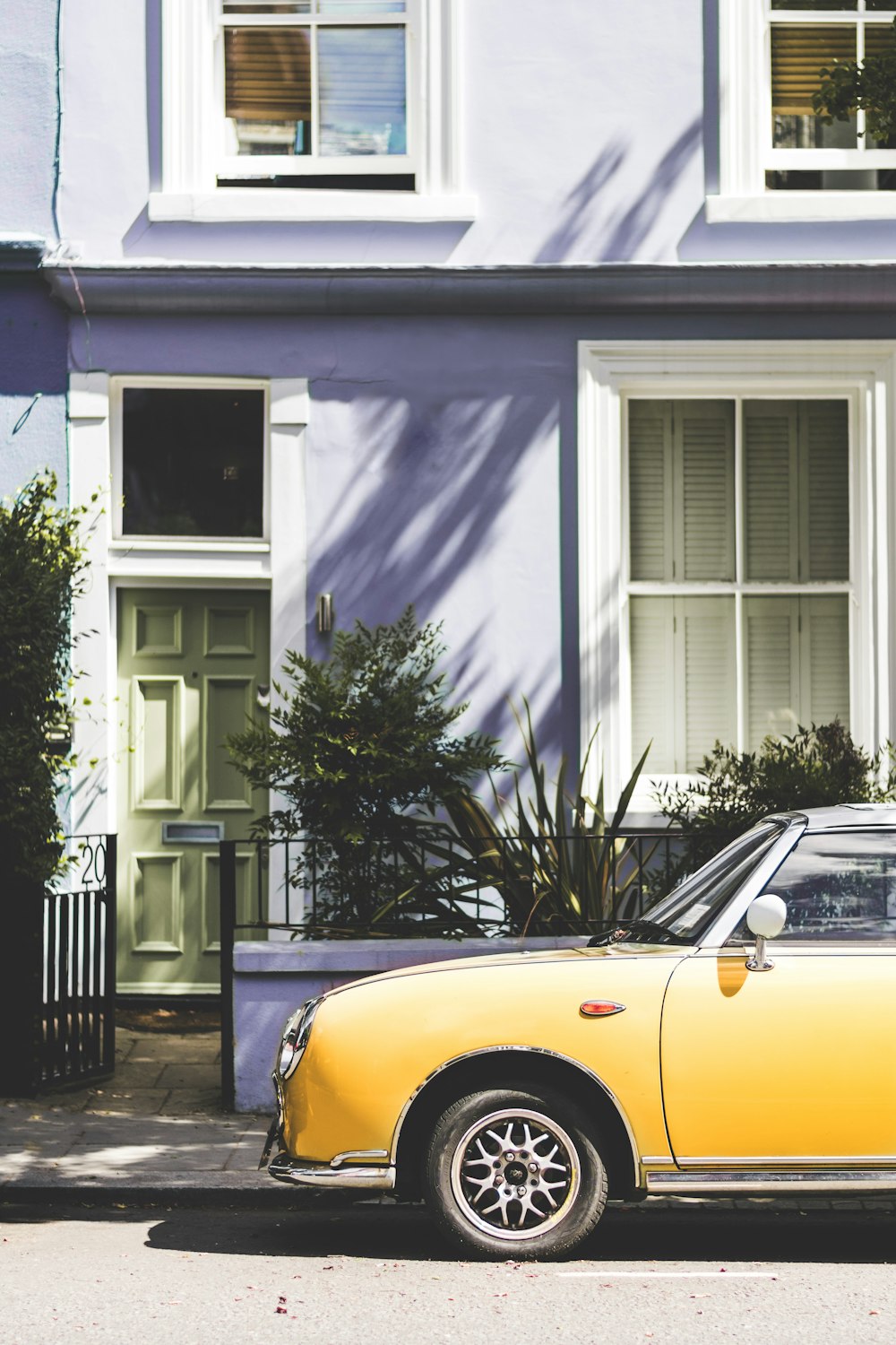 yellow car parked outside house