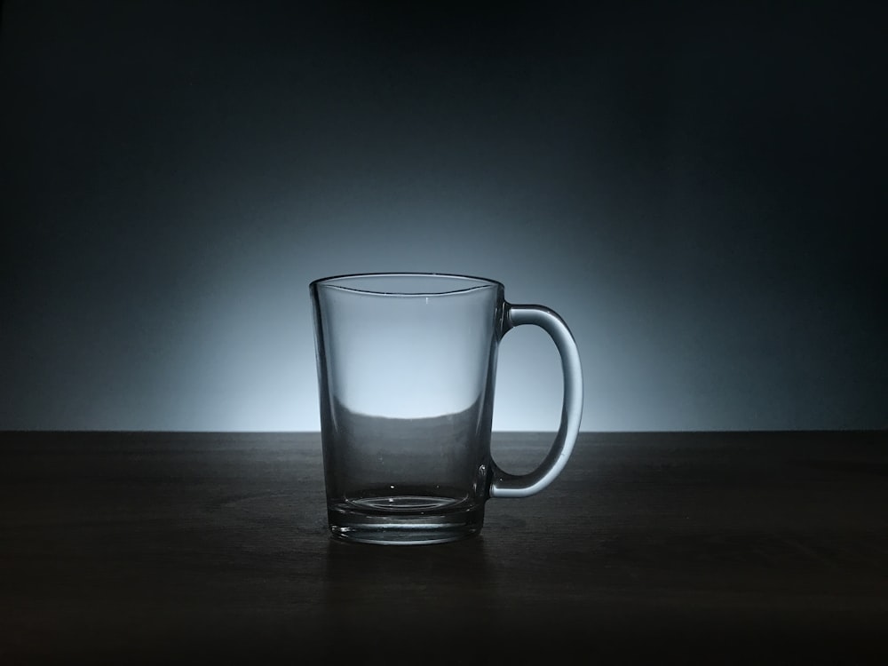 茶色の木の表面に透明なガラスのマグカップ