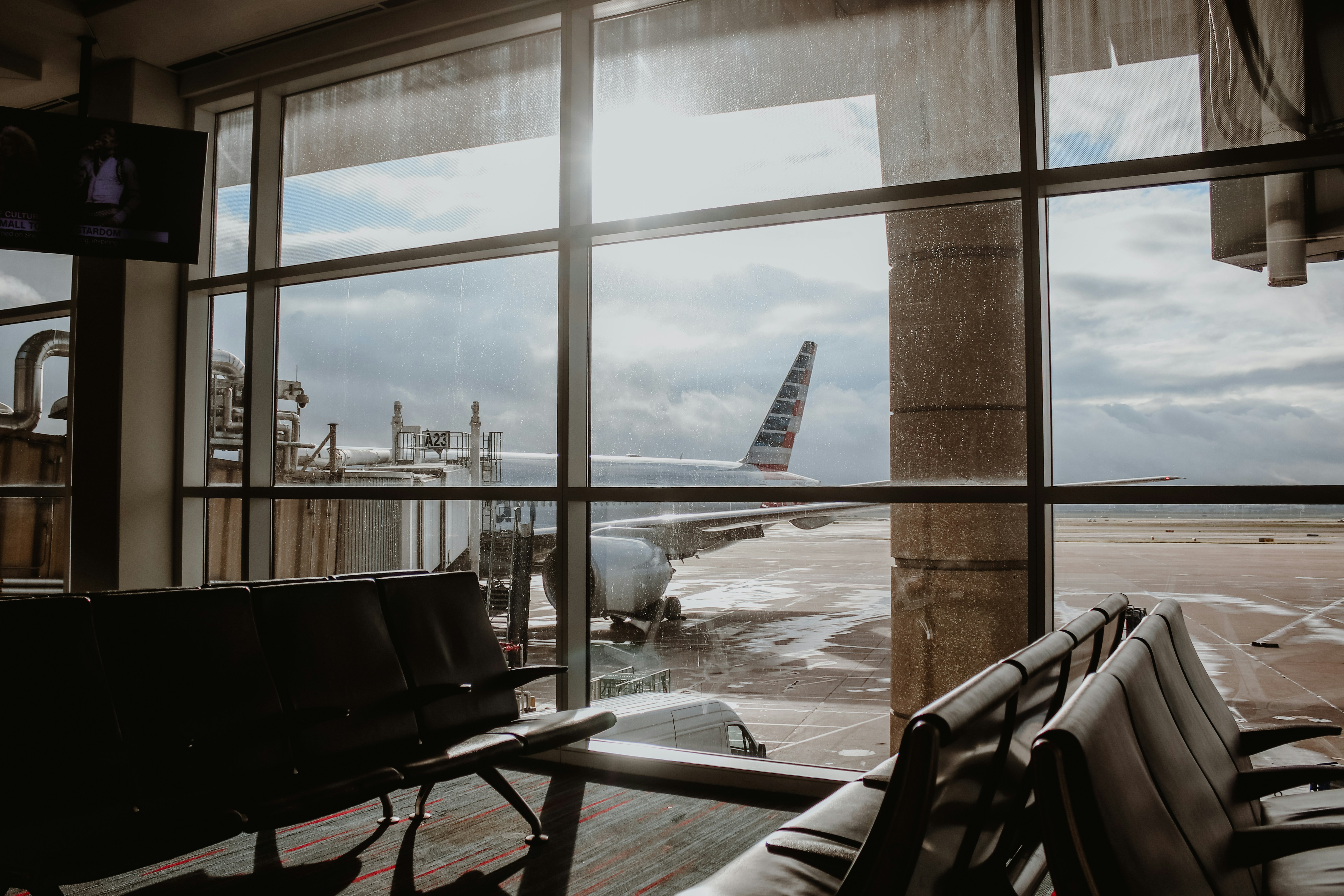 white and red plane view from glass window of waiting area, Just watching the planes come and go and dreaming about wonderful adventures and far off places.