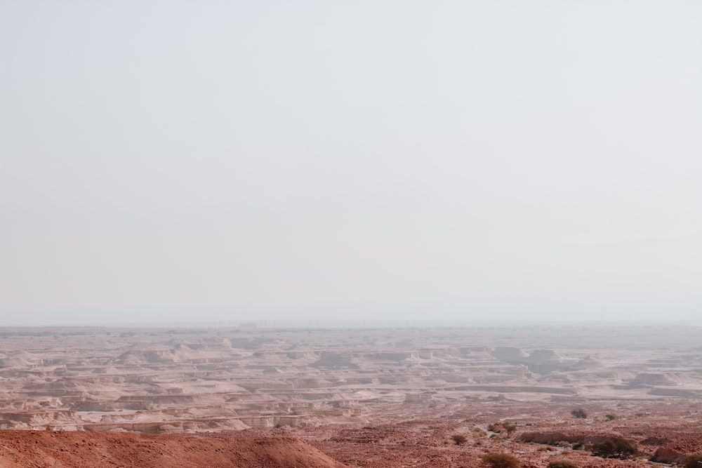 a dirt field with a hill in the distance