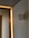 A minimalist interior with a clean, modern design. Soft lighting creates a warm ambiance along the wooden paneling. The neutral tones of the walls and ceiling complement the subtle geometric features.