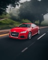 red Audi coupe on road near trees at daytime