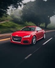 red Audi coupe on road near trees at daytime