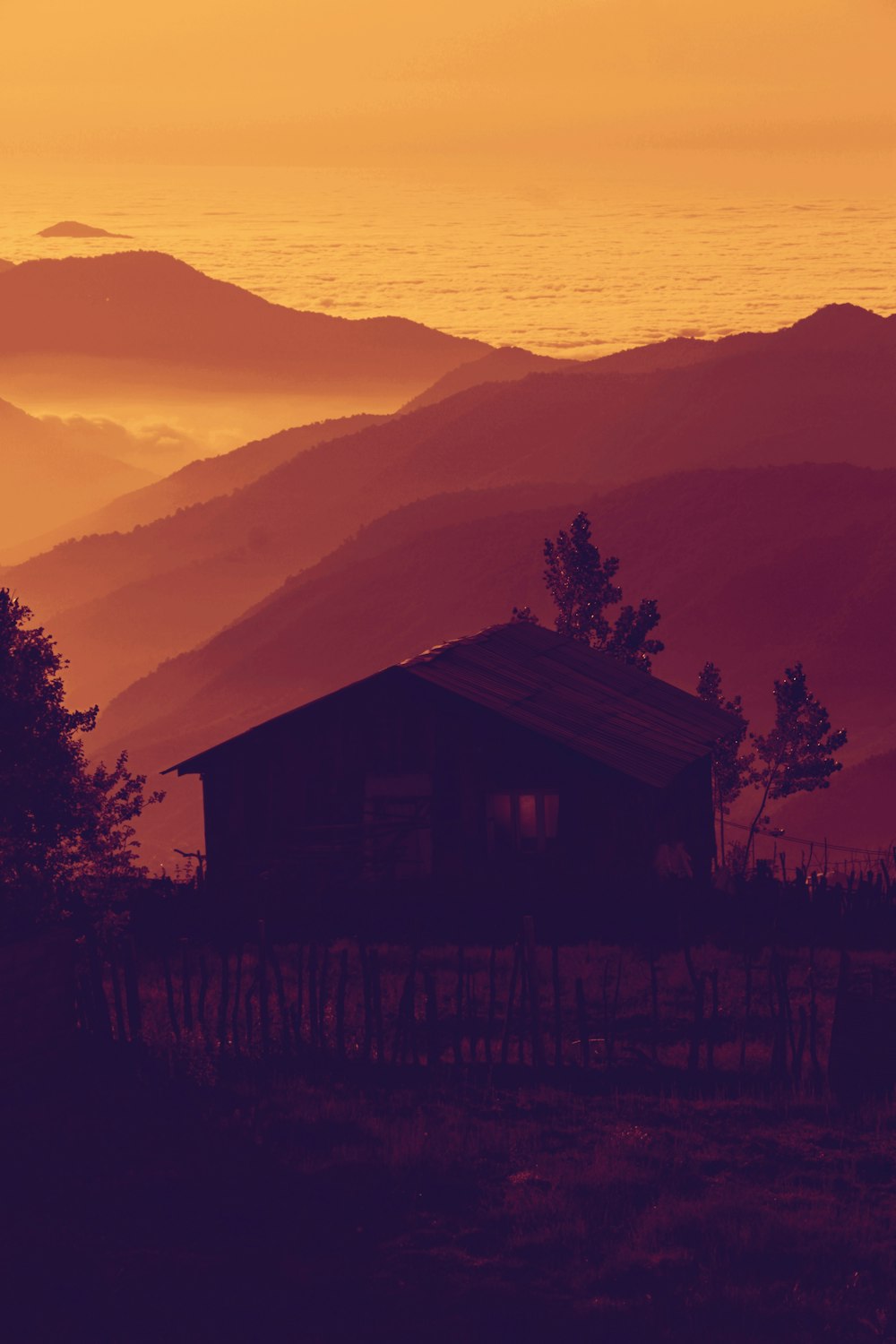 silhouette of brown house near mountains