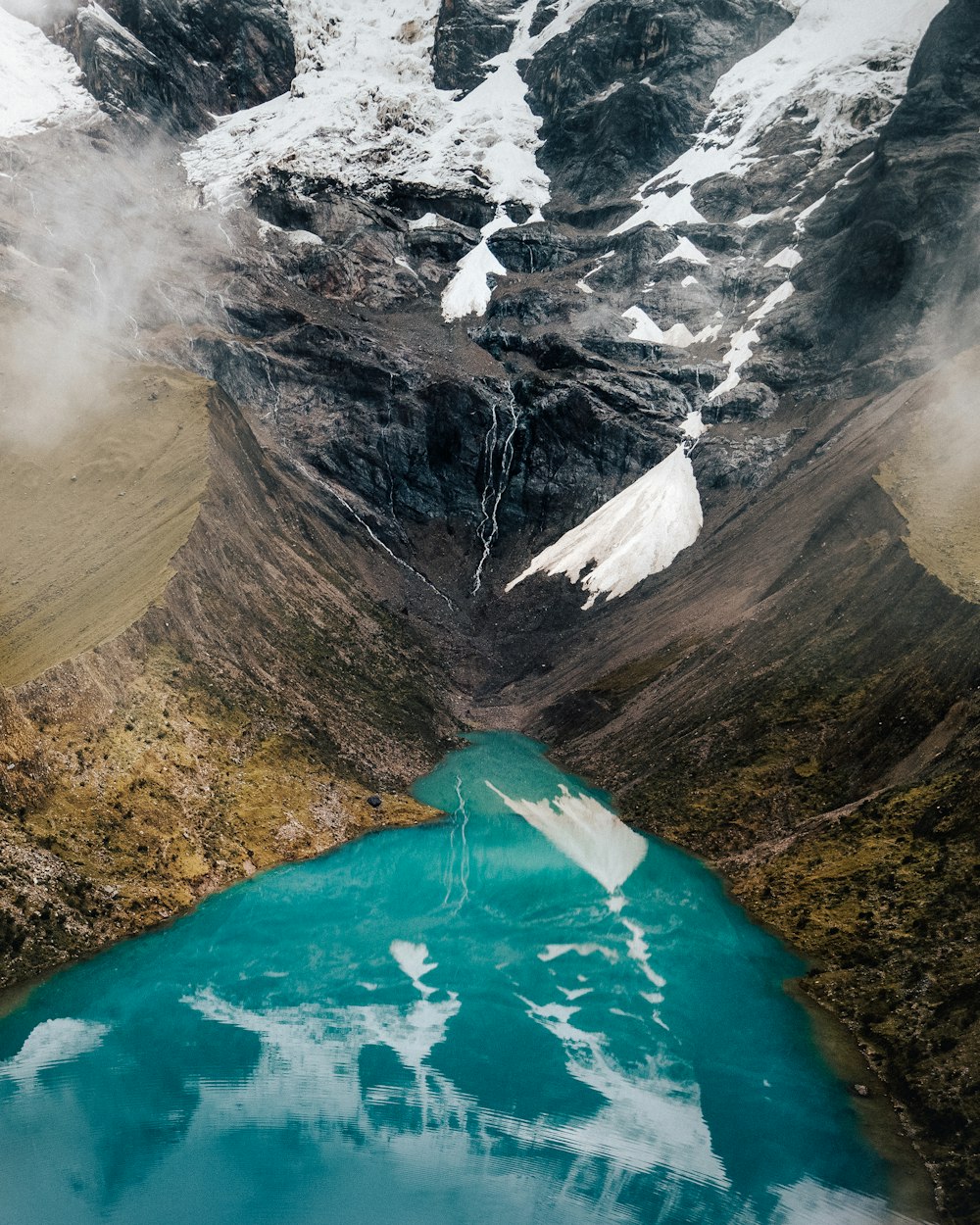 specchio d'acqua tra le montagne durante il giorno