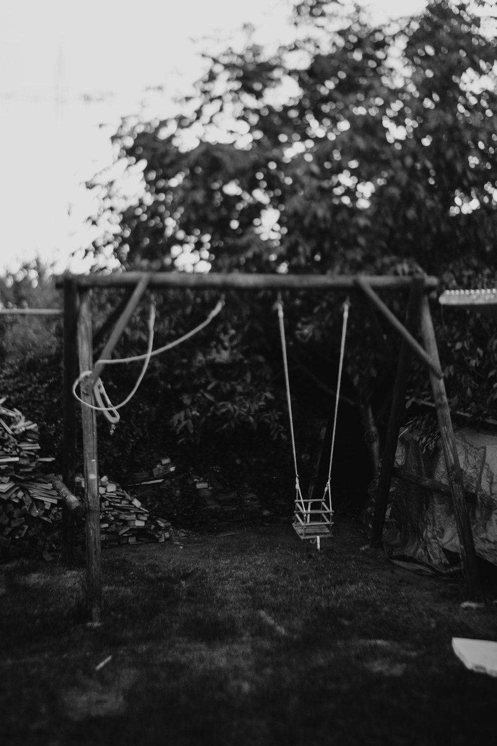 grayscale photo of swing at the garden