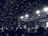 A candid shot of a teen crowd jumping and cheering at a nighttime outdoor concert.