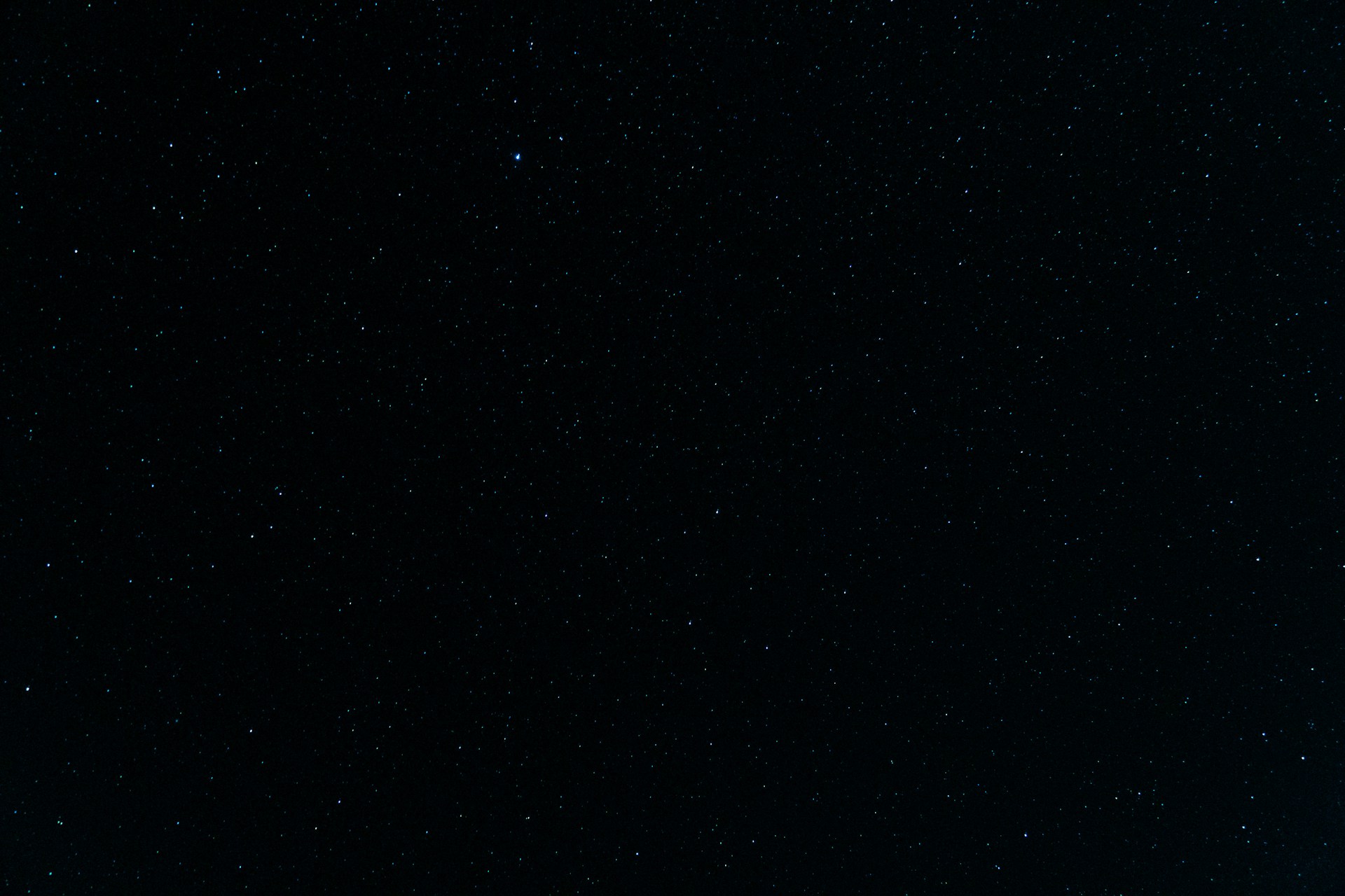 a night sky with stars and a plane in the foreground