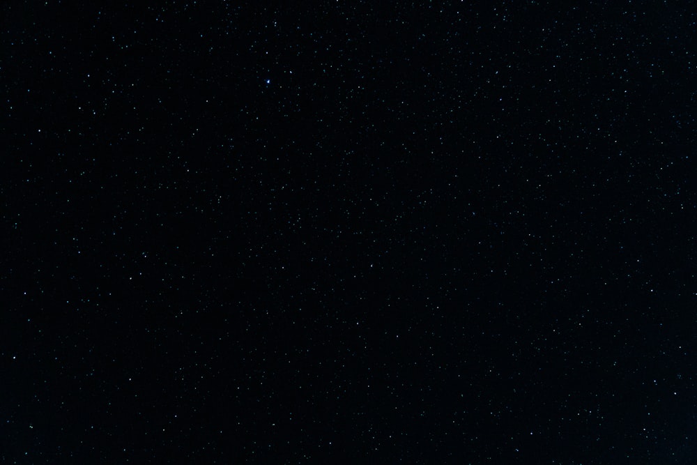 Un cielo nocturno con estrellas y un avión en primer plano