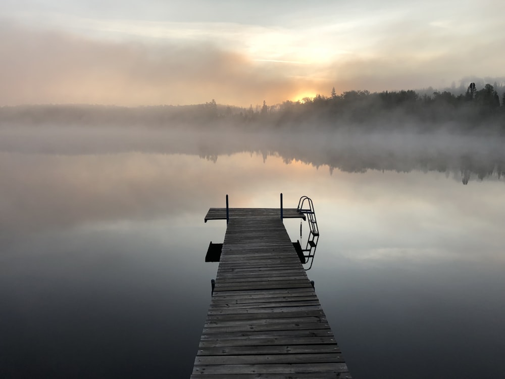 gray wooden pallet sea dock with fog