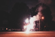 A nighttime street scene in Kodambakkam with fireworks lighting up the sky above the depot.
