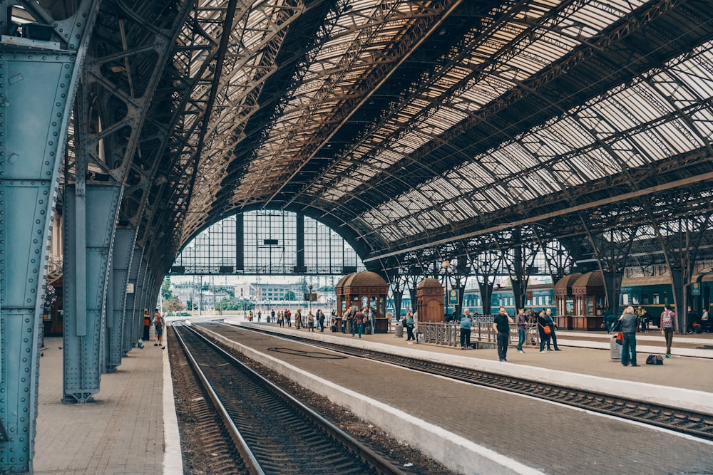 Personnes debout à l’intérieur de la station grise pendant la journée