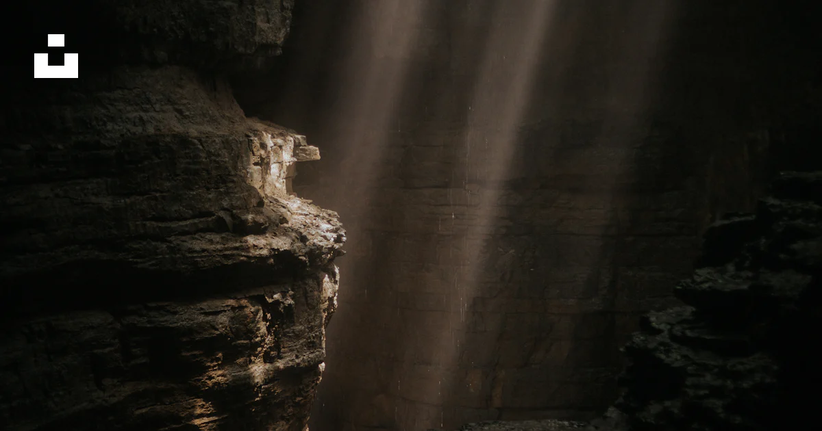 A light shines through a crack in the rocks photo – Free Light Image on ...