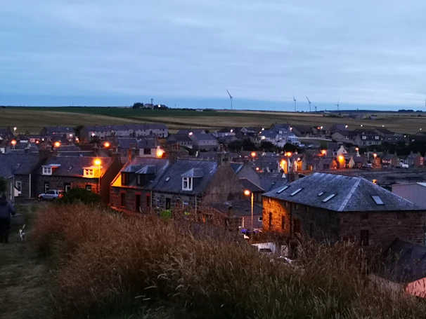 A vibrant village scene at dusk, homes lit up by Visiontech’s sustainable electricity.