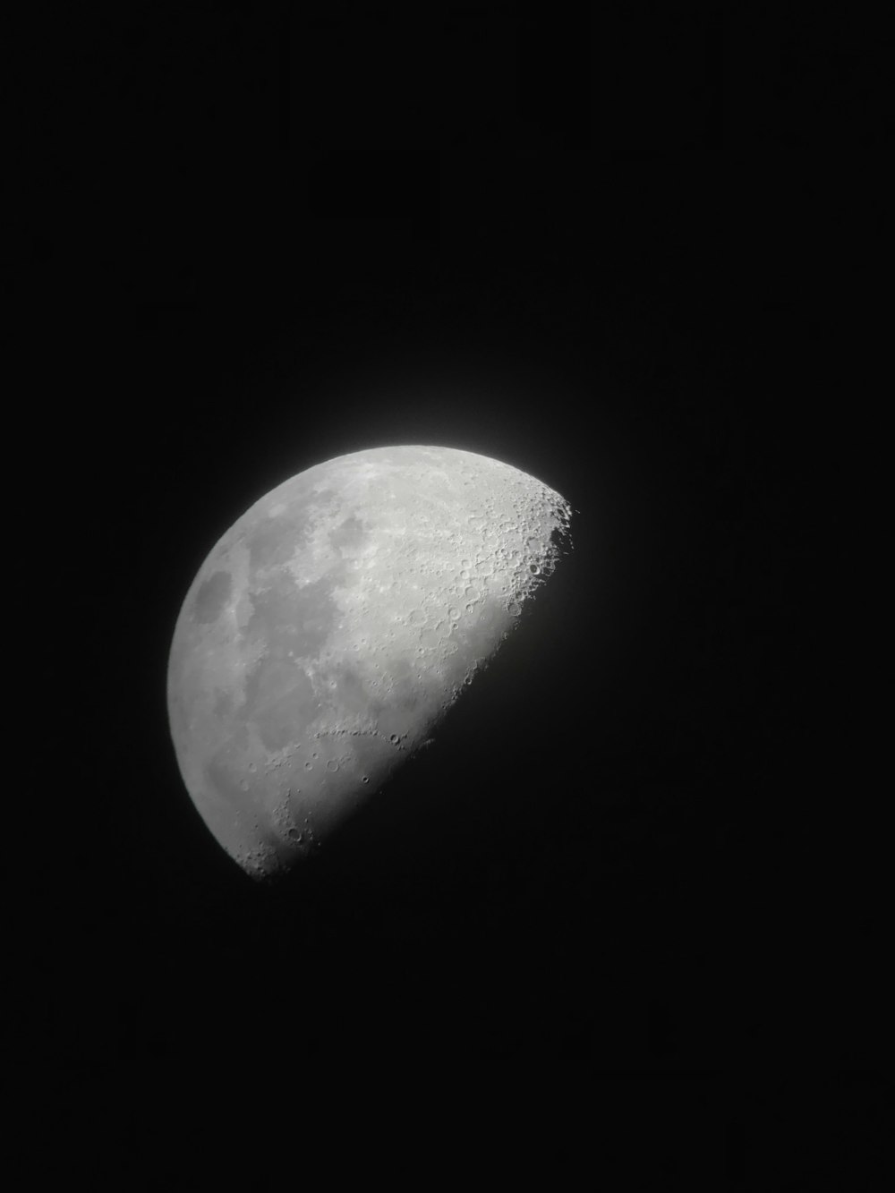 Un gros plan d’une demi-lune dans le ciel sombre