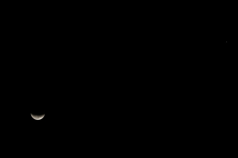 the moon is seen in the dark sky