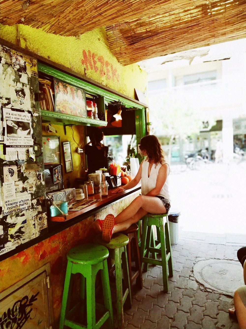 woman sitting on stools near bar counter during daytime