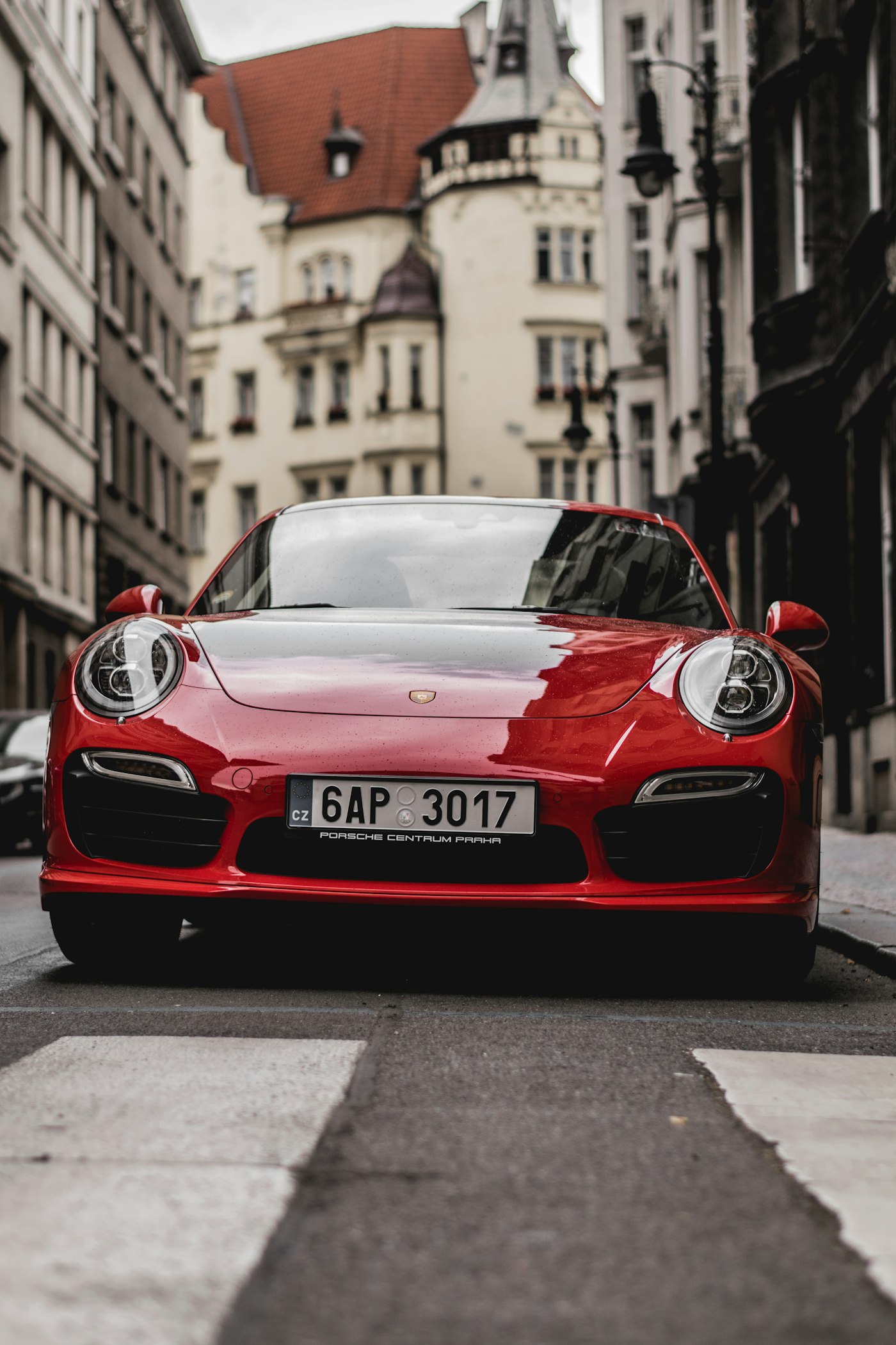 Red luxury vehicle framed by modern architecture