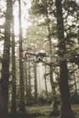 A drone flying low over a forested area during a surveillance mission.