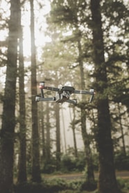 gray and black DJI Mavic Pro quadcopter drone on mid top air near forest at daytime