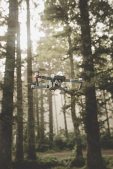 A sleek aerki drone swarm navigating through a dense forest canopy at dawn.
