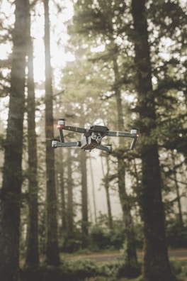 A drone flying low over a forested area during a surveillance mission.