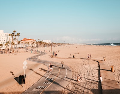 people on road and sand california teams background