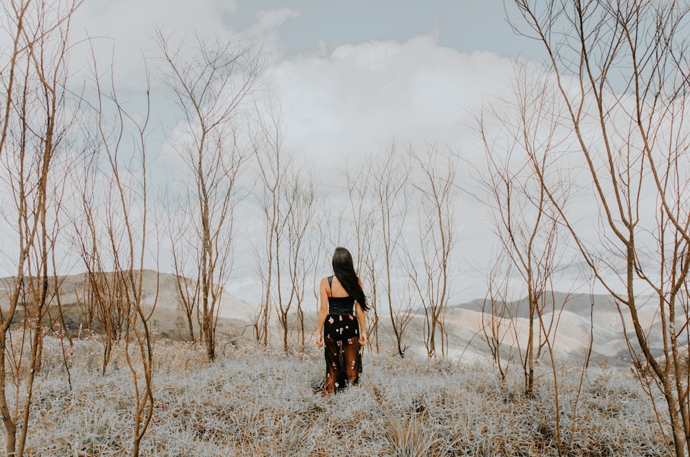 woman standing on gray field under cloudy sky