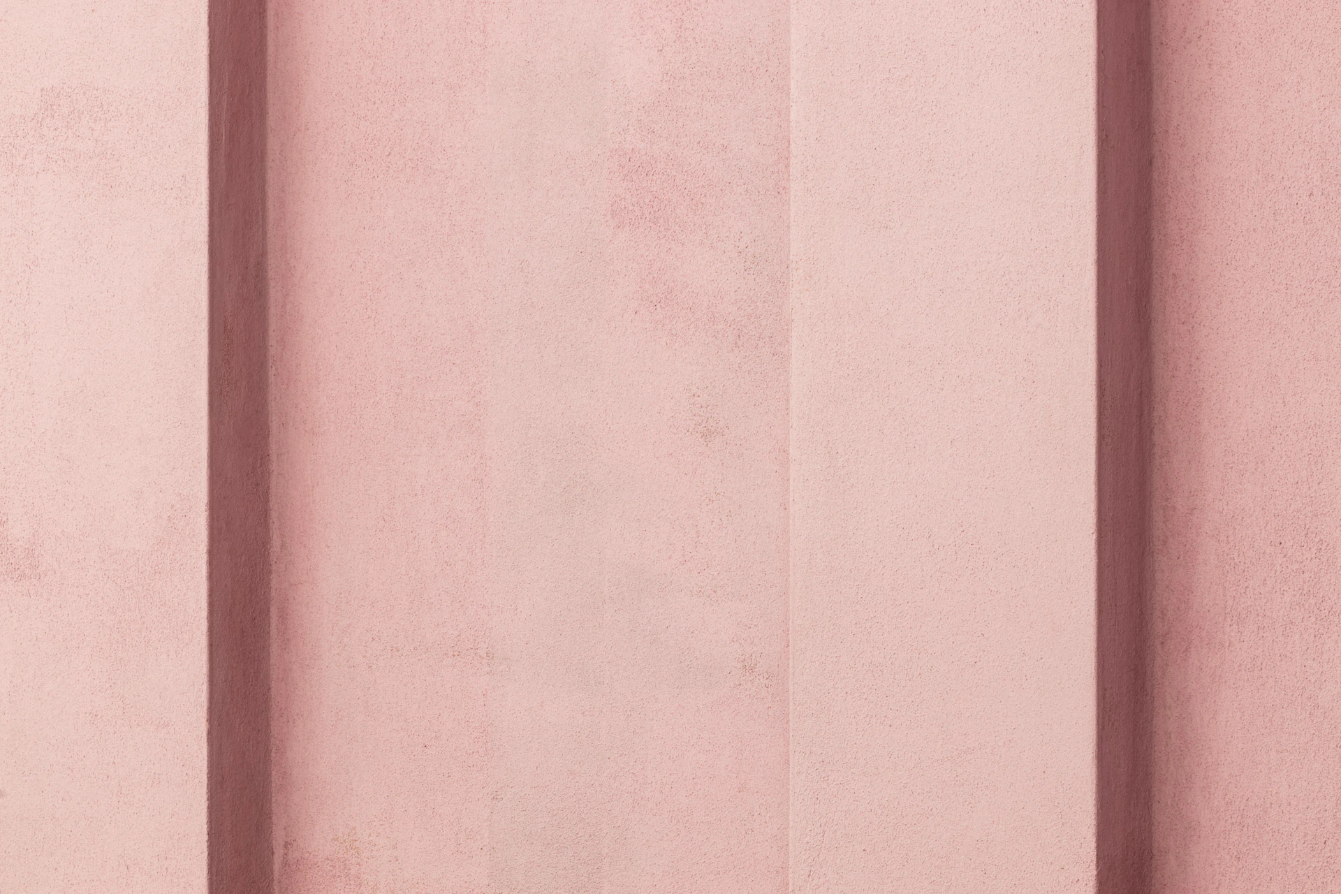 a pink wall with vertical lines on it