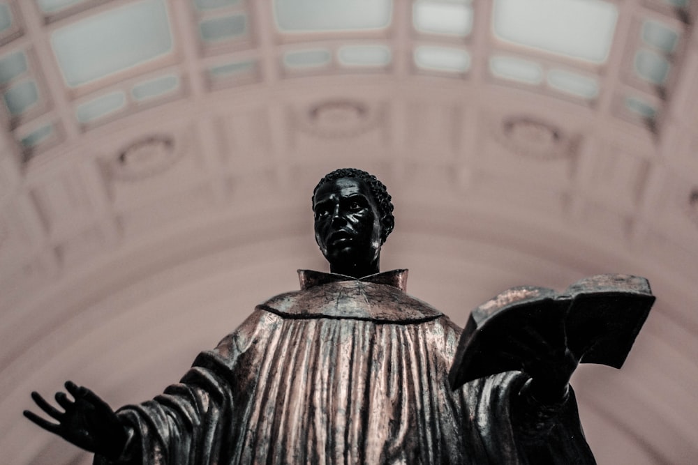 priest holding bible statue