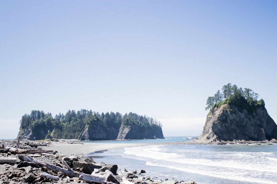 landscape photography of rocky island under clear blue sky,