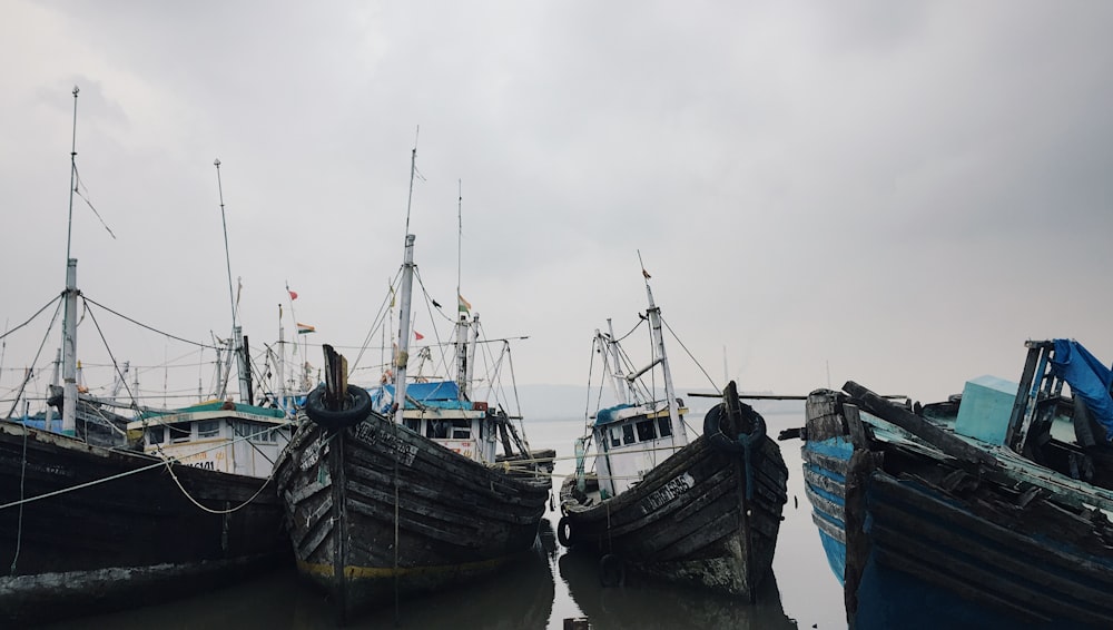 six white-and-black boats on seashore under cloudy sky during daytime