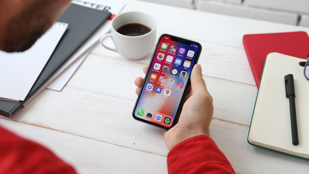 persona sosteniendo el espacio gris iPhone X