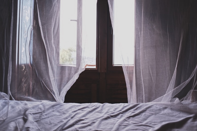 white bedspread beside window